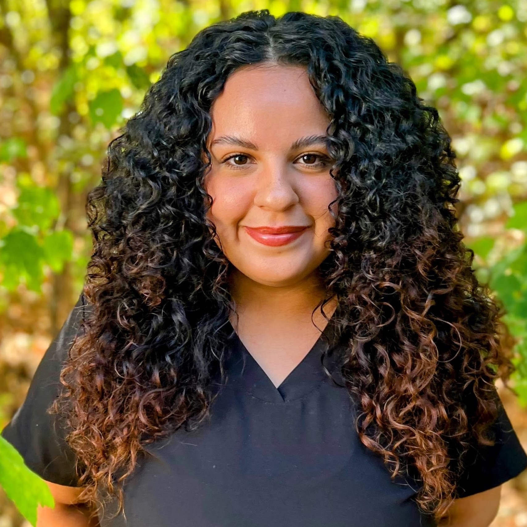 Ashley smiling with her black curly hair
